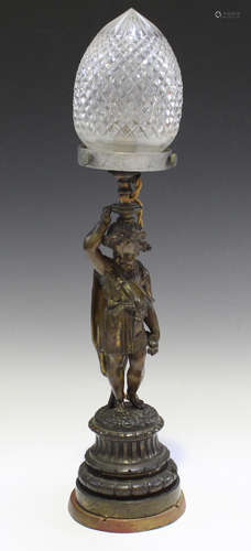 A late 19th century brown patinated cast bronze figural table lamp, later fitted with a cut glass