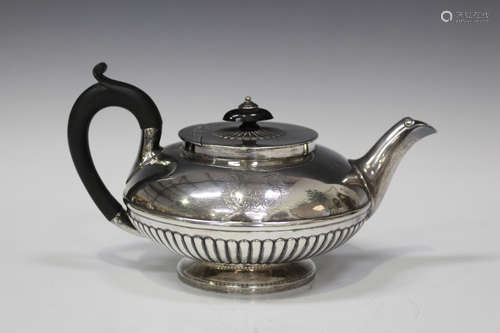 A George IV silver teapot of half-reeded squat circular form, engraved with an armorial, London 1823