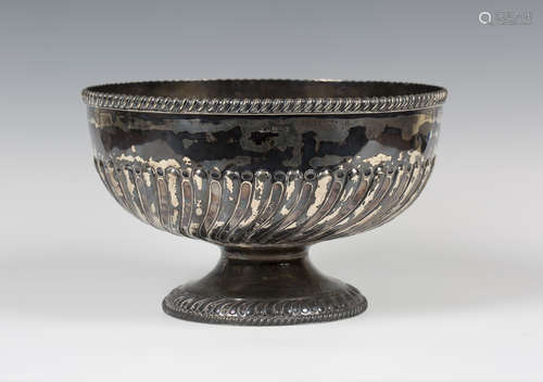 A late Victorian silver rose bowl, the half-reeded and fluted body beneath a gadrooned rim, on a