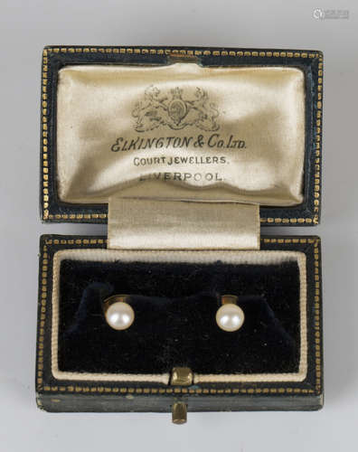 A pair of gold and cultured pearl dress studs, detailed '18ct', with a case.Buyer’s Premium 29.4% (