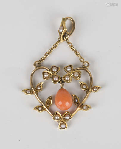 A gold, coral and seed pearl pendant, circa 1910, in a heart shaped floral and foliate openwork