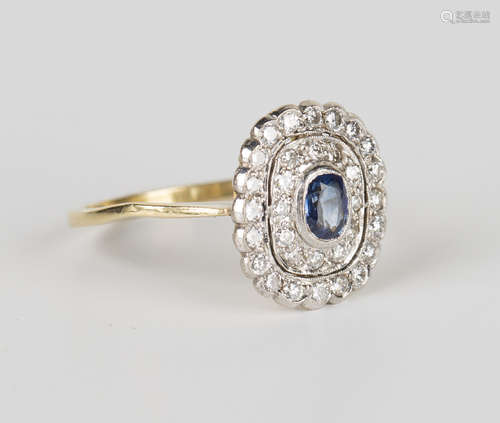 A gold, sapphire and diamond oval cluster ring, collet set with an oval cut sapphire within a two