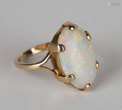 A gold ring, claw set with an oval opal, ring size approx O1/2.Buyer’s Premium 29.4% (including