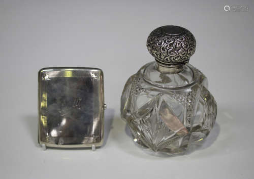 An Edwardian silver mounted cut glass scent bottle, the globular body with facet and diamond cut
