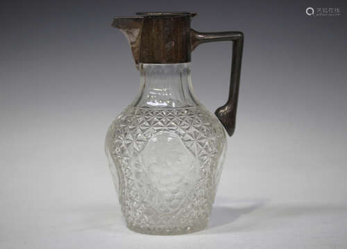 An Edwardian silver mounted cut glass claret jug, the baluster body engraved and cut with four