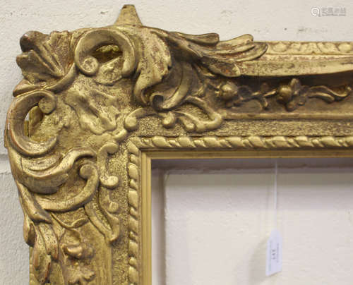 A late 19th/early 20th century gilt composition picture frame of wide section with foliate and