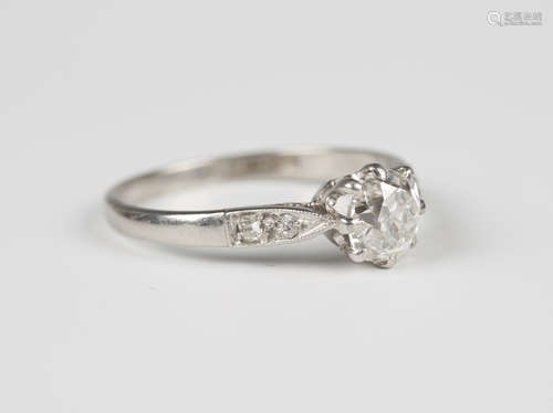 A platinum and diamond ring, claw set with the principal cushion cut diamond between diamond two