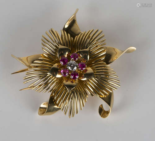 A French gold, ruby and diamond brooch in a stylized floral design, claw set with a circular cut