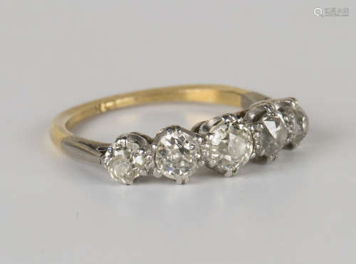 A gold and diamond five stone ring, claw set with a row of cushion cut diamonds graduating in size