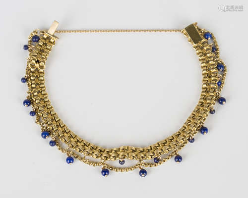 A gold and lapis lazuli bead bracelet in a two row multiple chain link and fringe design, the