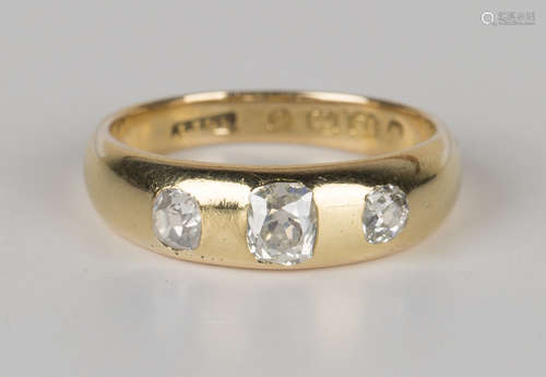 A Victorian 18ct gold and diamond three stone ring, gypsy set with a row of cushion cut diamonds,