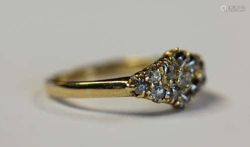 A gold and diamond cluster ring, mounted with cushion cut diamonds, detailed '18ct', ring size