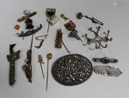 A group of jewellery, including four mostly silver brooches, a charm bracelet, various loose charms,