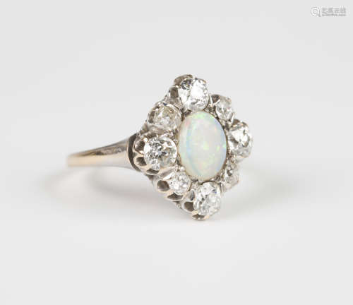 An opal and diamond lozenge shaped cluster ring, mounted with an oval opal within a surround of