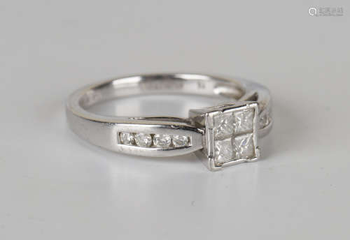 A platinum and diamond ring, mounted with four princess cut diamonds between circular cut diamonds