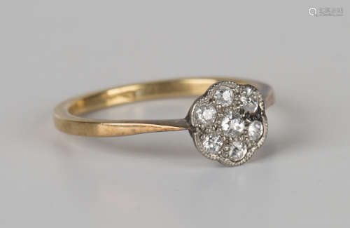 A gold and diamond seven stone cluster ring, mounted with cushion cut diamonds, detailed '18ct',
