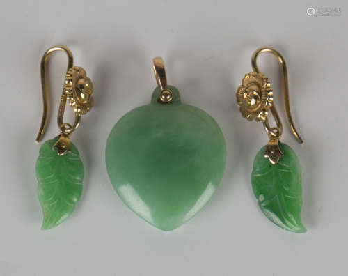 A pair of gold mounted jade pendant earrings, each jade drop carved as a leaf, the gold surmounts