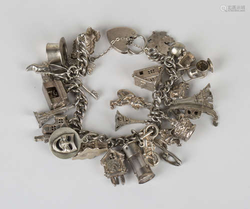 A curblink charm bracelet, fitted with a variety of mostly silver charms, including a cottage, a