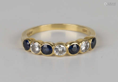 An 18ct gold, sapphire and diamond set seven stone half-hoop ring, mounted with four circular cut