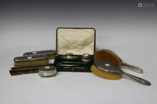 A George V silver four-piece dressing table set with foliate reeded borders, comprising hairbrush,