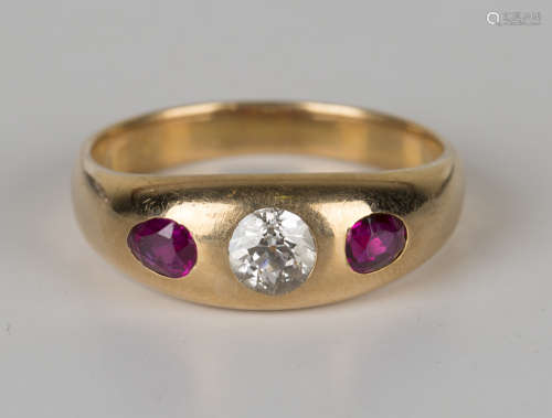 A gold, diamond and ruby three stone ring, gypsy set with a cushion cut diamond between two gypsy