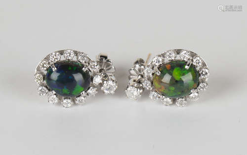 A pair of white gold, black opal and diamond pendant earrings, each oval black opal within a