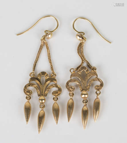 A pair of gold pendant earrings, each mounted with three graduated drops beneath a scrolling
