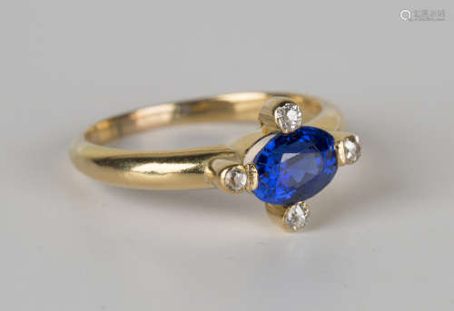 A gold, sapphire and diamond ring, mounted with an oval cut sapphire within a surround of four