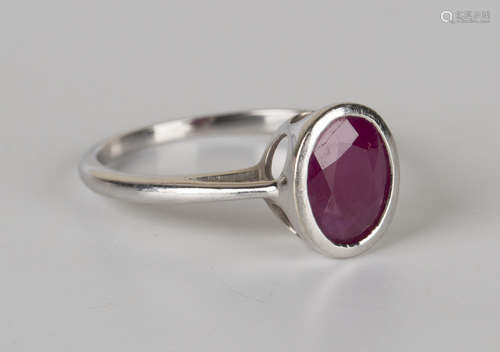 An 18ct white gold ring, collet set with an oval cut ruby, detailed 'Iliana', ring size approx N.