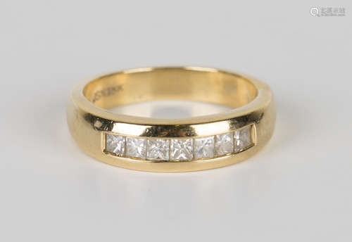 An 18ct gold and diamond ring, mounted with a row of seven princess cut diamonds, ring size approx