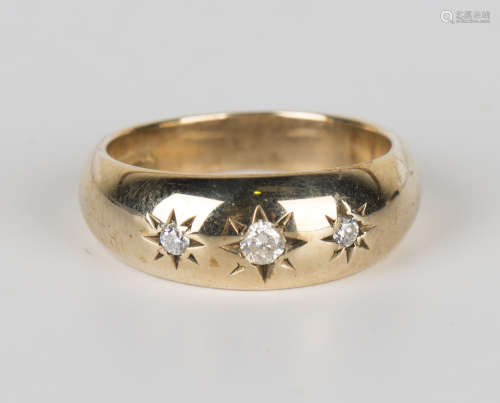 A 9ct gold and diamond three stone ring, star gypsy set with circular cut diamonds, ring size approx