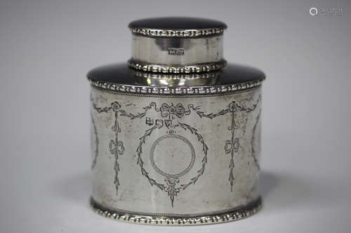 A George V silver oval tea caddy, engraved with opposing bellflower pendant cartouche and bellflower