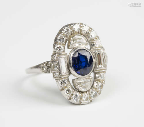 A platinum, diamond and sapphire panel shaped cluster ring, mounted with the oval cut sapphire