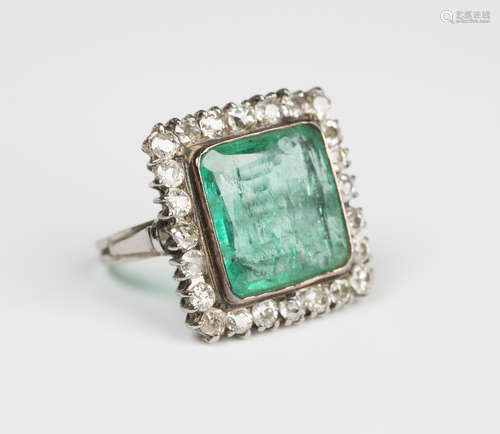 A white gold, emerald and diamond square cluster ring, mounted with a large square cut emerald