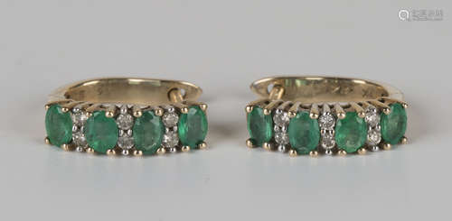 A pair of 9ct gold, emerald and diamond earrings, each mounted with four oval cut emeralds