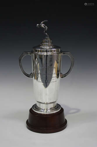 A George VI silver trophy cup and cover with an ice skater finial, the tapering cylindrical body