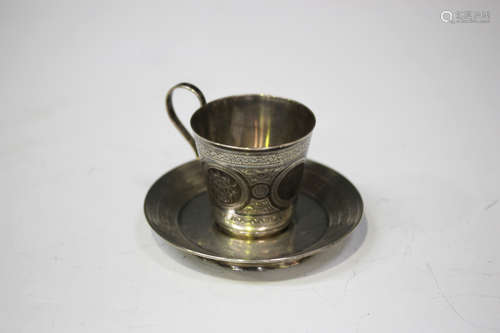 A late 19th century Russian silver cup and saucer, 84 zolotnik, the cup engraved with floral