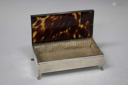 A George V silver and tortoiseshell rectangular dressing table box, raised on claw and ball feet,