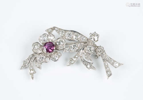 A diamond and ruby brooch, designed as a floral spray, the flowerhead centre claw set with a cushion