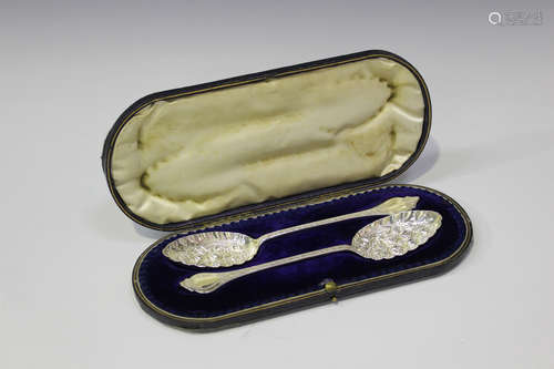 A pair of Edwardian silver fruit spoons, each bowl embossed and engraved with fruits and flowers,