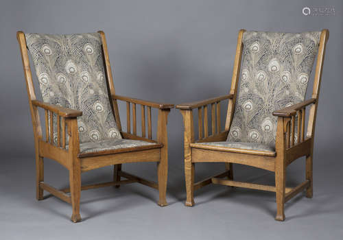 A pair of early 20th century Arts and Crafts oak framed armchairs, in the manner of Shapland &