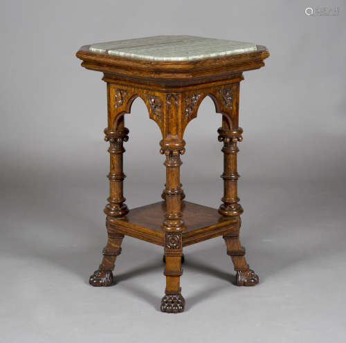 An early 20th century Gothic Revival oak two-tier table, the canted square top inset with a