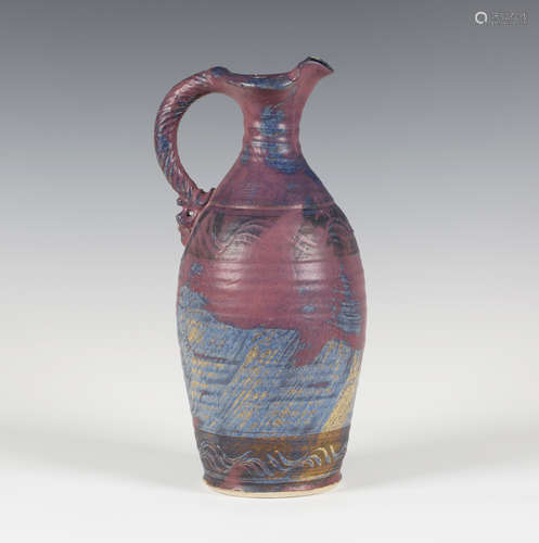 An Irish Michael Kennedy Pottery stoneware jug, the gently ribbed ovoid body covered in a purple