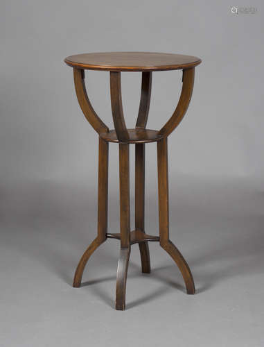 An Edwardian Arts and Crafts walnut circular three-tier occasional table, in the manner of J.S.