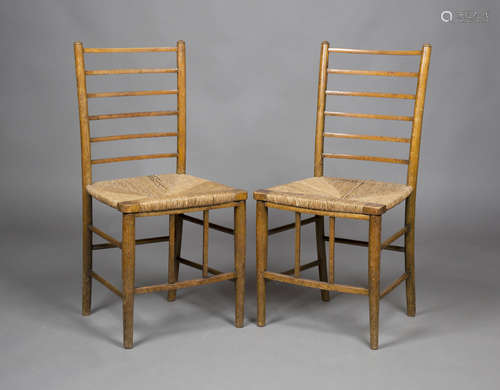 A pair of Edwardian Arts and Crafts stained beech rail back bedroom chairs with rush seats and