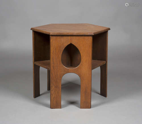 An early 20th century Arts and Crafts oak hexagonal book table, three sides pierced with teardrop