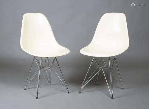 A pair of modern Eames 'DSR' chairs, the cream moulded plastic seats raised on chromium plated '