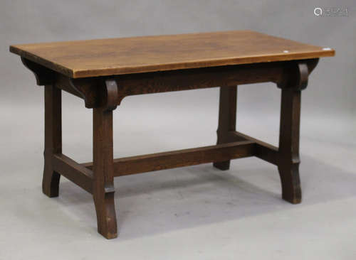 An early 20th century Arts and Crafts stained oak rectangular centre table, raised on shaped