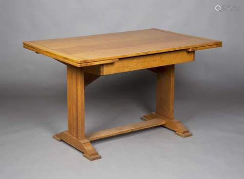 An early 20th century pale oak drawleaf dining table, raised on shaped supports and bracket feet,