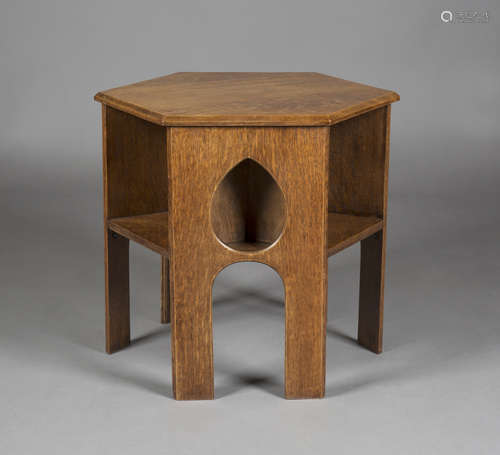 An early 20th century Arts and Crafts oak hexagonal book table, three sides pierced with teardrop